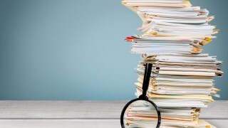 File folders with documents and magnifying glass on the desk