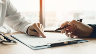 Business advisor financial man pointing on contract paper to customer reading contract.