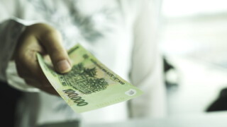 Close up of asian woman's hand holding vietnam bank note make payment at shop or supermarket. Asia currency exchange or finance concept. Vietnamese giving money or opportunity support in investment.