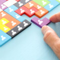 image of tangram puzzle blocks with people icons over wooden table ,human resources and management concept.