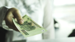Close up of asian woman's hand holding vietnam bank note make payment at shop or supermarket. Asia currency exchange or finance concept. Vietnamese giving money or opportunity support in investment.