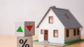 Wooden blocks percentage sign, arrow up and down with house model background. Central bank FED control interest rate increase or decrease effect to house price, monthly payment, buying home concept.