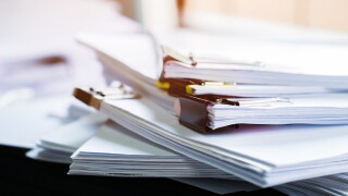 Stack of papers documents in archives files with clip papers on table at offices,  Busy offices and Pile of data unfinished folders on office desk indoor near window,  Business concept.