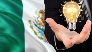 Mexico creativity concept. Businessman with a light bulb in his hand on national background. Innovation and technology theme.