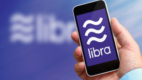 Man holding a smartphone in his hand with the libra logo, the new crypto currency created by facebook company