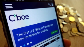 KONSKIE, POLAND - MAY 14, 2018: CBOE Global Markets website displayed on smartphone and stack of coins