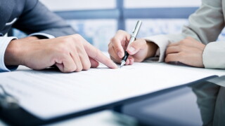 Female hand signing contract.